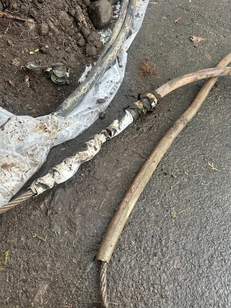 Old copper water line pulled out of the ground on a steel cable