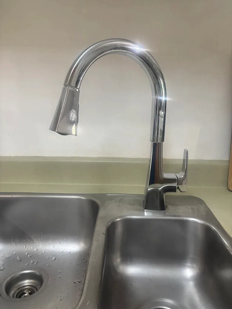 Chrome pull-down kitchen faucet over a double sink