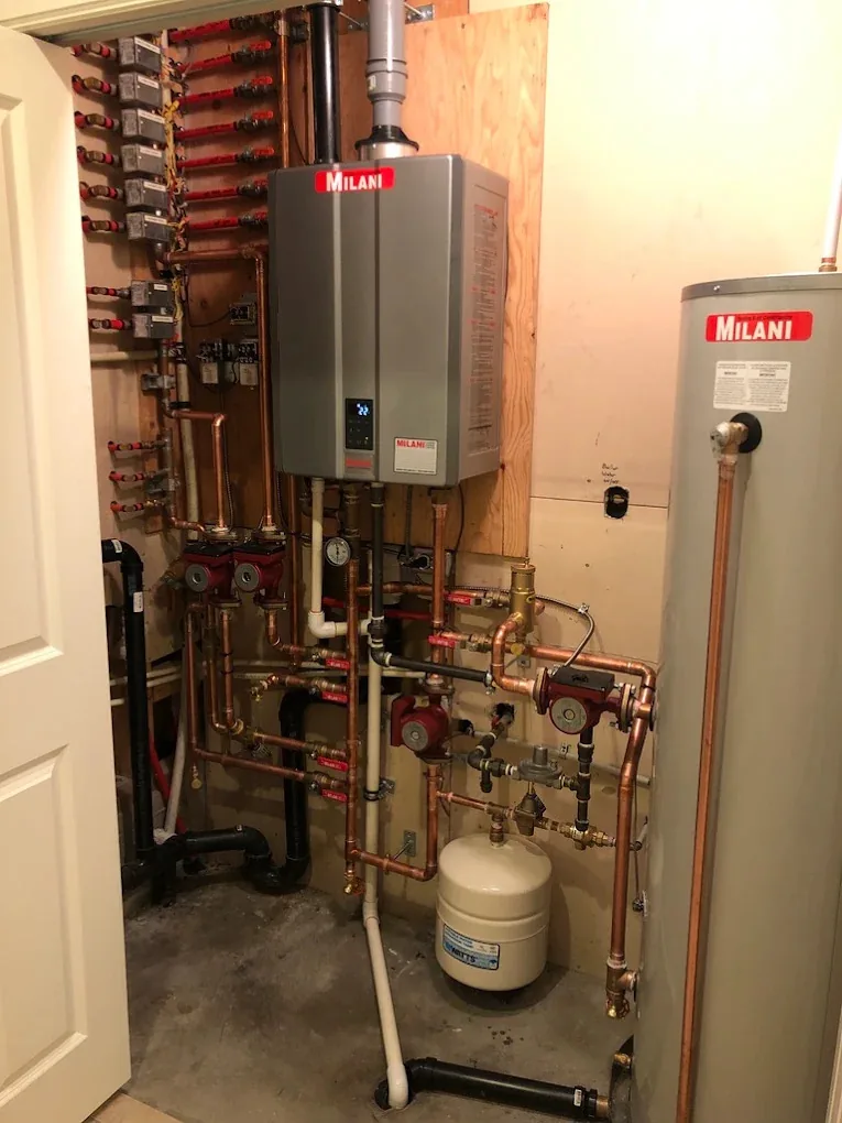 Water heater with a copper heating manifold, pumps, and zone valves installed in a utility room