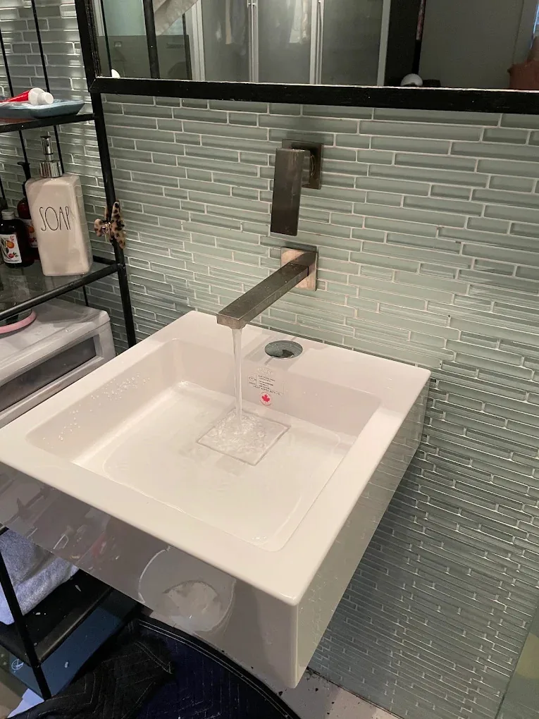 Wall-mounted sink with a square wall-mounted faucet running